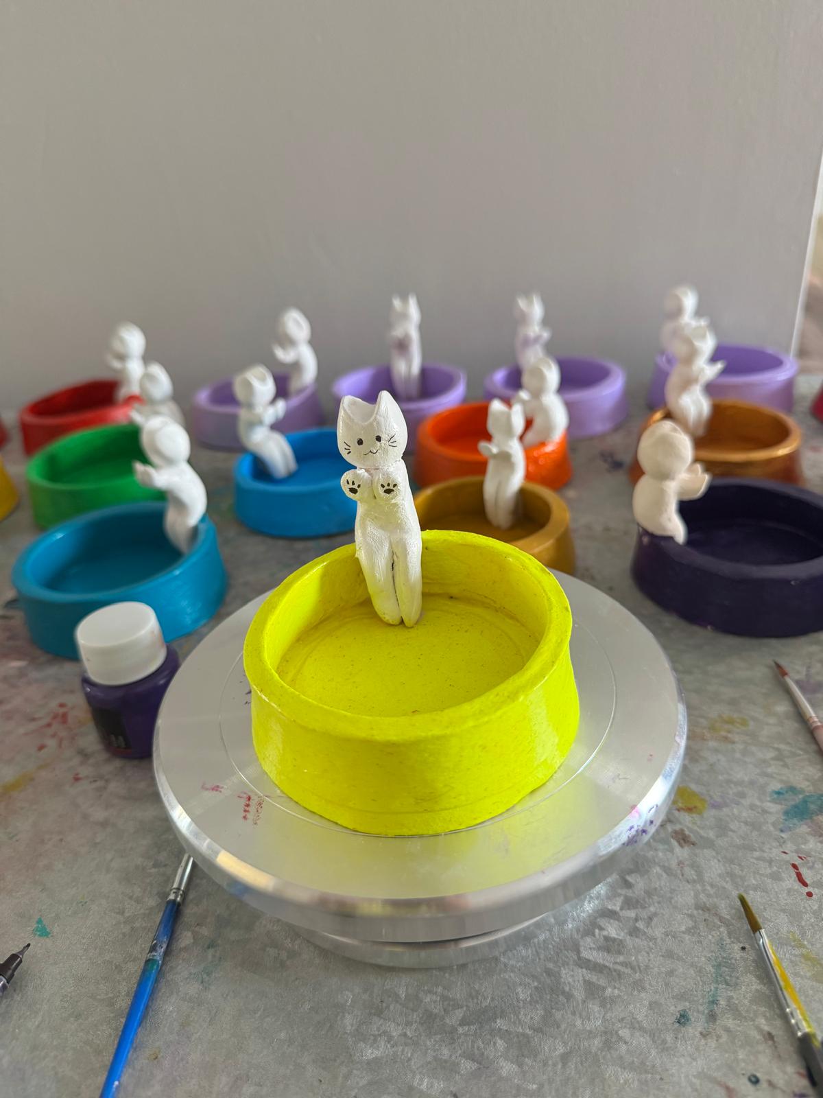 Hand-built pottery bowl with sculpted cat figure on yellow glaze